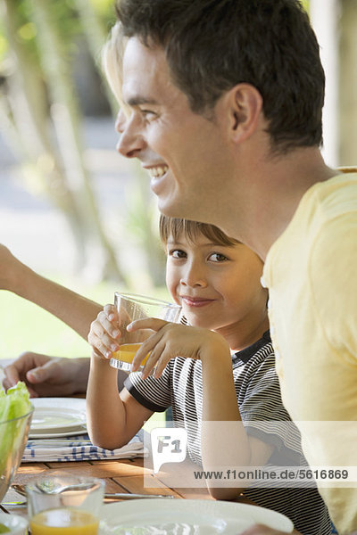 Boy having breakfast with family outdoors
