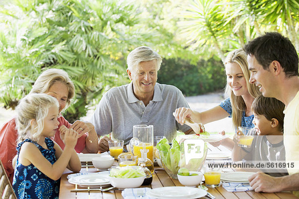 Multi-generation family having breakfast together outdoors