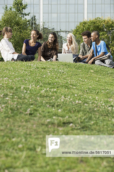Young friends spending time outdoors on grass  low angle view