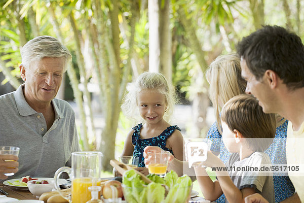 Multi-generation family having breakfast outdoors