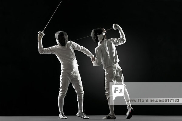 One fencer pointing fencing foil at the other fencer