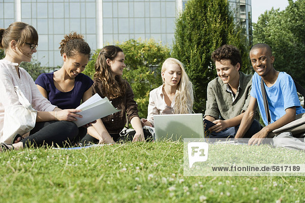 University students studying on grass outdoors  low angle view