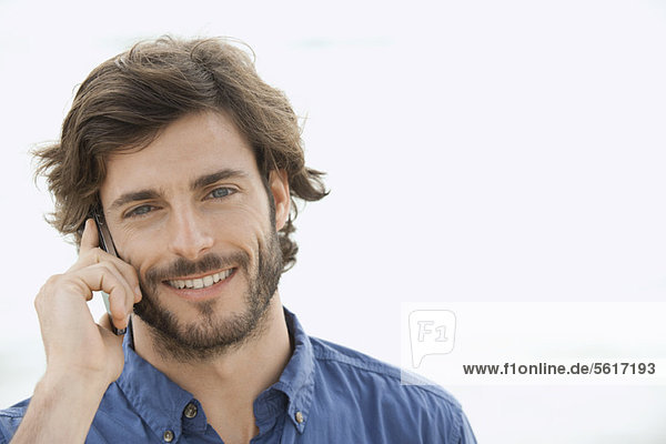 Mann mit Handy im Freien  lächelnd  Portrait