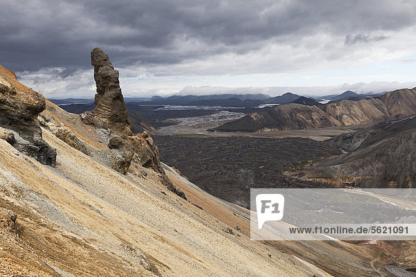 Ein phallisch geformter Fels auf dem Berg Brennisteinsalda in den Rhyolith-Bergen bei Landmannalaugar  mit Blick auf ein großes Lavafeld und das Fjallabak Naturschutzgebiet  Hochland von Island  Europa