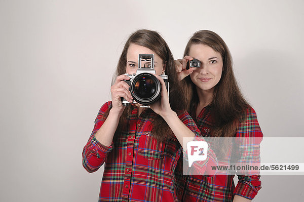 Zwillingsschwestern mit Kameras  eine mit Pentacon Six Mittelformat Analogkamera  die andere mit einer Mini-Spielzeug-Kamera