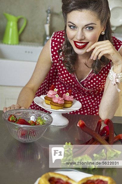 A retro-style girl with strawberry muffins  strawberries and rhubarb