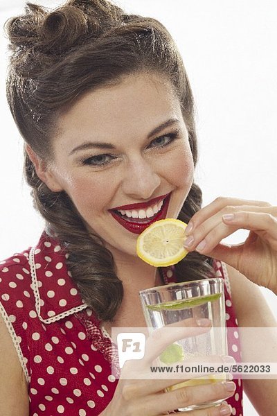 Mädchen im Retro-Look trinkt Zitronenlimonade