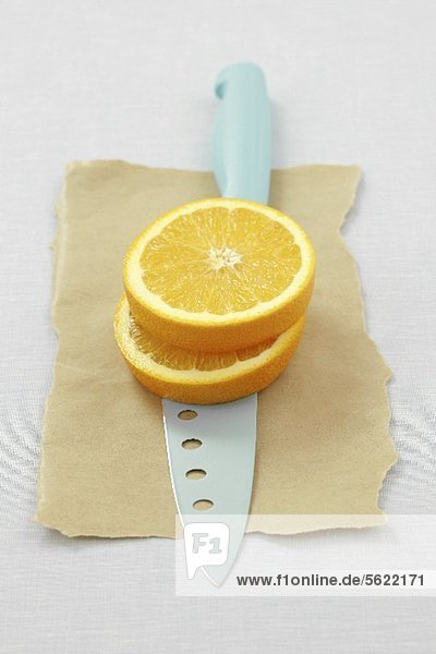 Two orange slices on a knife