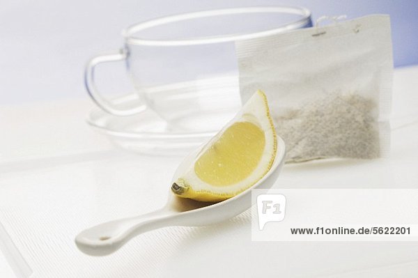 Zitronenschnitz auf Löffel  Teebeutel und Teetasse