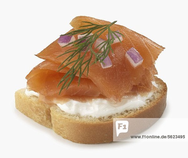 Slice of Bread Topped with Cream Cheese and Smoked Salmon  Red Onion and Dill  White Background