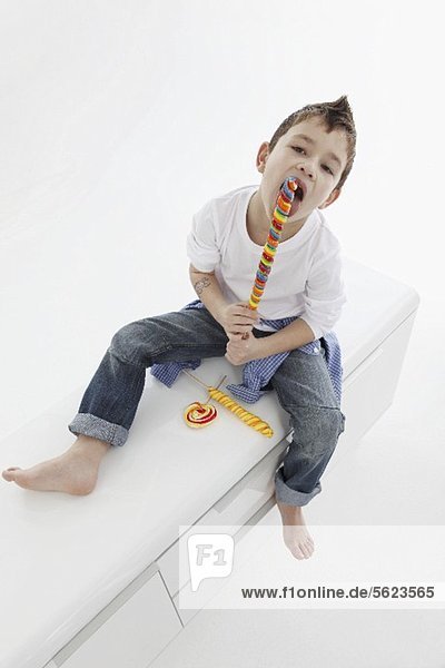 A little boy eating a giant lolly