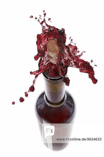 Rotwein spritzt aus der Flasche