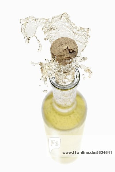 Weisswein spritzt aus der Flasche