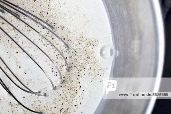 Milk with Pepper and Nutmeg in a Metal Bowl with Whisk