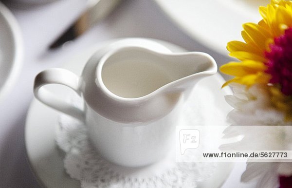 Pitcher of Cream on a Table  Flowers