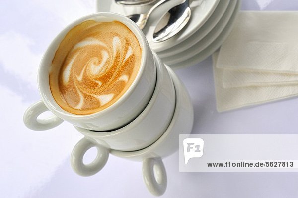 Tassenstapel mit einem Cappuccino obenauf