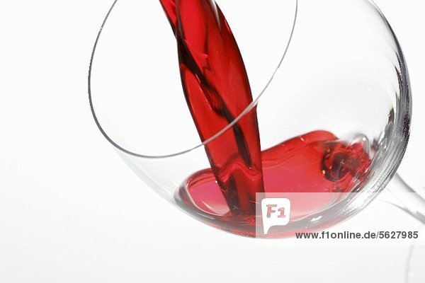 Rotwein fliesst ins Weinglas