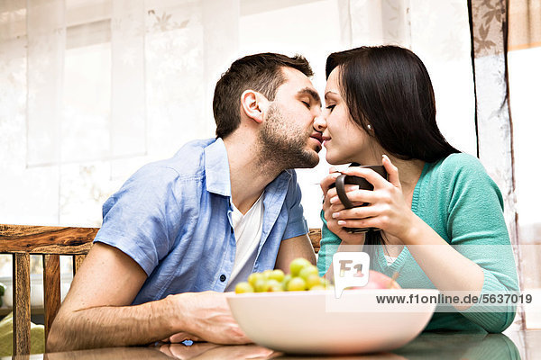 Küssendes junges Paar zu Hause