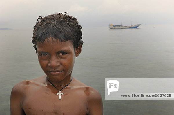 Christian Papua boy wearing a cross on a necklace while bathing in Kota Biak  Biak Island  Irian Jaya  Indonesia  Southeast Asia  Asia
