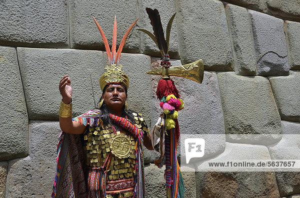 Indio man dressed as an Inca in front of a seamless  ancient wall of the Incas  tourist center of Cuzco  Peru  South America