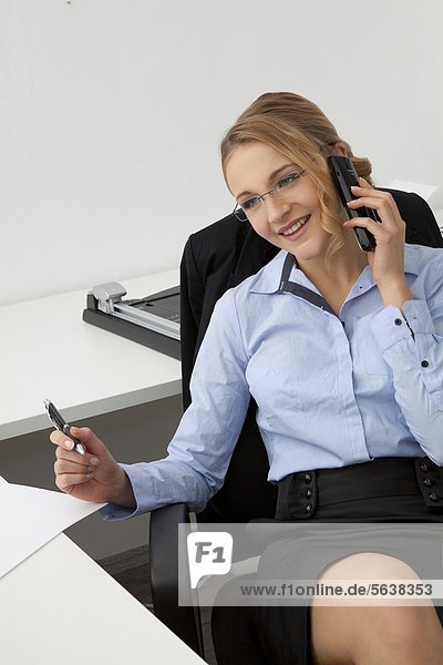 Young woman in office on the phone