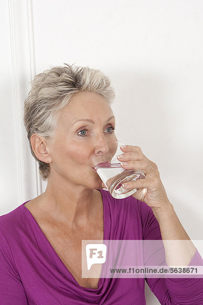 Older woman drinking glass of water