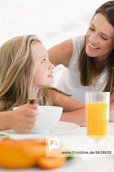 Mother talking to daughter at breakfast