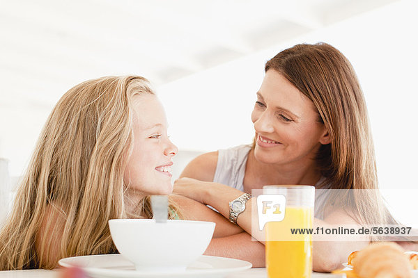 Mutter im Gespräch mit Tochter beim Frühstück