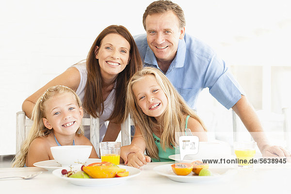 Familie lächelt am Frühstückstisch