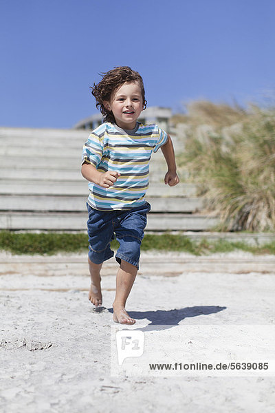 Boy running on sandy beach