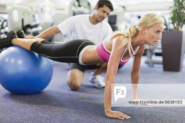 Woman working with trainer in gym