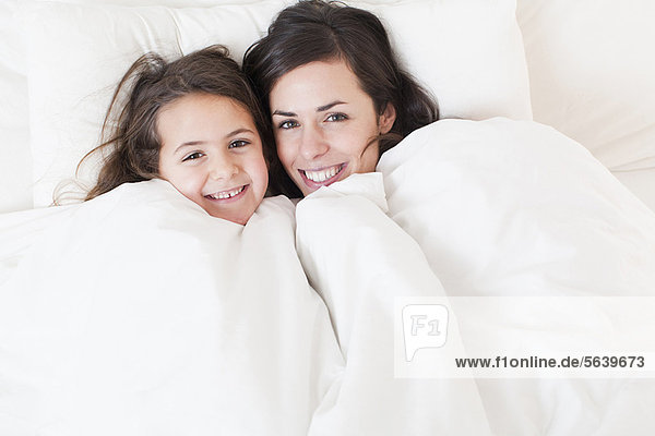 Mother and daughter relaxing in bed