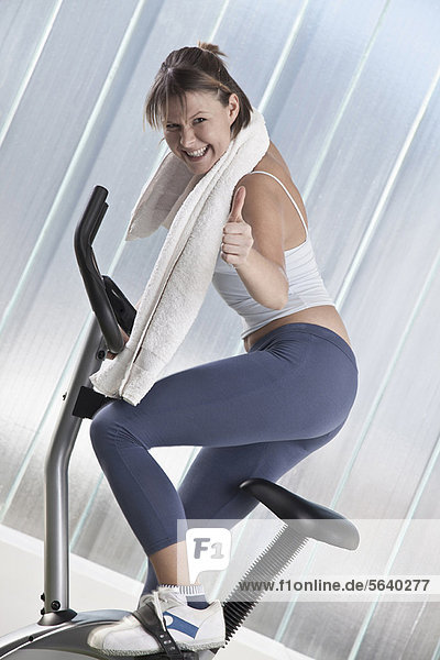 Woman cheering on exercise machine