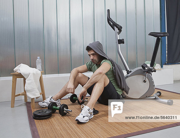 sitzend  Fitness-Studio  Mann  Boden  Fußboden  Fußböden  zu Hause