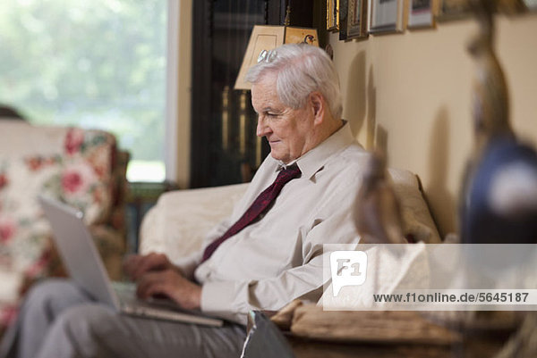 A businessman using a laptop at home