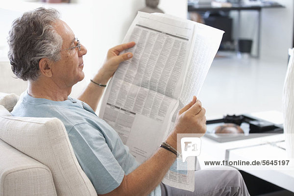 Ein älterer Mann  der die Zeitung liest.