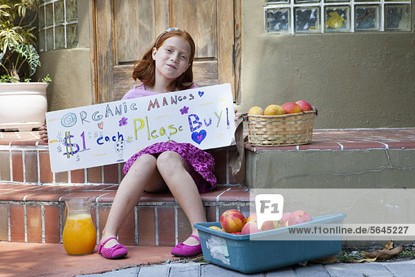 Mädchen verkauft Äpfel auf der Veranda