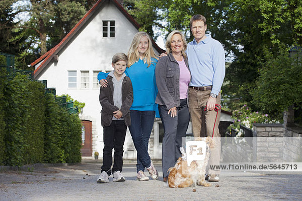 Ein Porträt einer vierköpfigen Familie und ihres Hundes