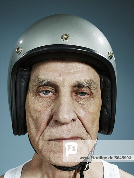 Ein Kopfschuss eines älteren Mannes  der einen Sturzhelm trägt.