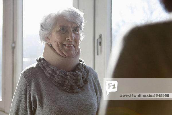 Eine lächelnde ältere Frau mit einer Halskrause.
