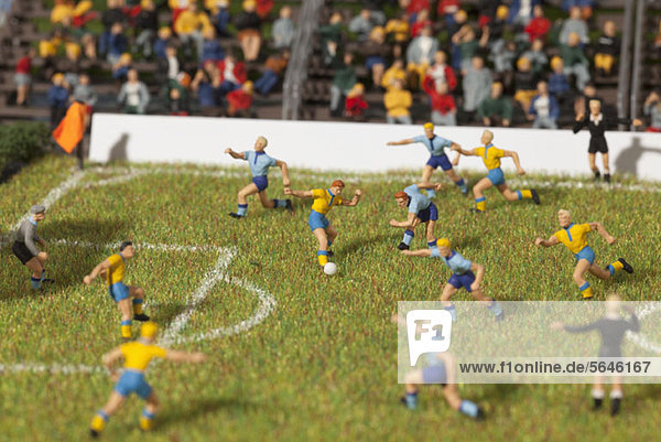 Miniaturfiguren zweier Fußballmannschaften bei einem Fußballspiel