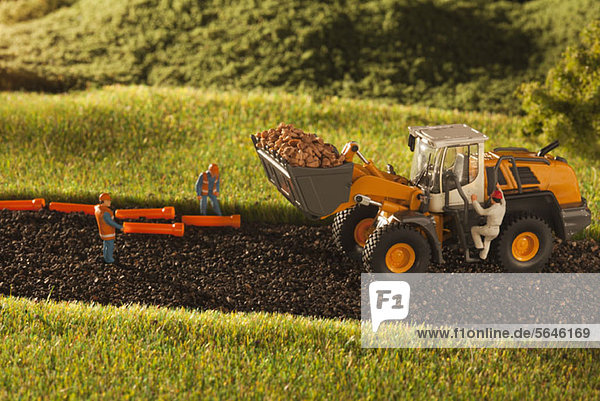 Ein Diorama von Miniaturbauarbeitern und einer Planierraupe