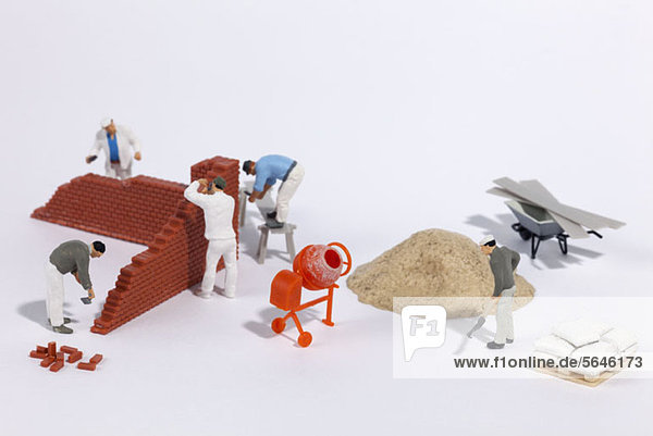 Miniaturmaurer beim Bau einer Ziegelwand