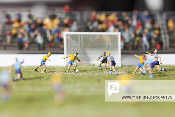 Miniaturfiguren zweier Fußballmannschaften bei einem Fußballspiel