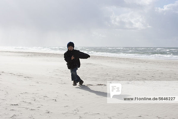 Junge  der am Strand rennt