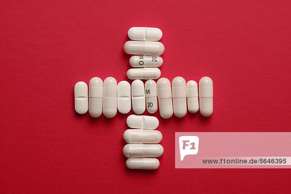 Capsules and tablets arranged in a cross shape