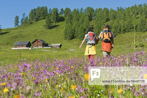 Austria  Salzburg  Couple walking through alpine meadow