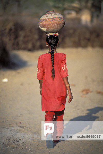 Girl carrying a jar on her head  village of Katariyasar near Bikaner  Rajasthan  Thar Desert  North India  India  Asia