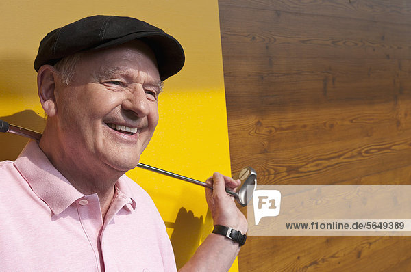 Germany  North Rhine Westphalia  Duesseldorf  Golfer on golf course  smiling