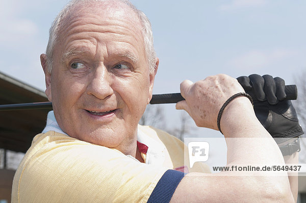 Germany  North Rhine Westphalia  Duesseldorf  Golfer playing golf  close up